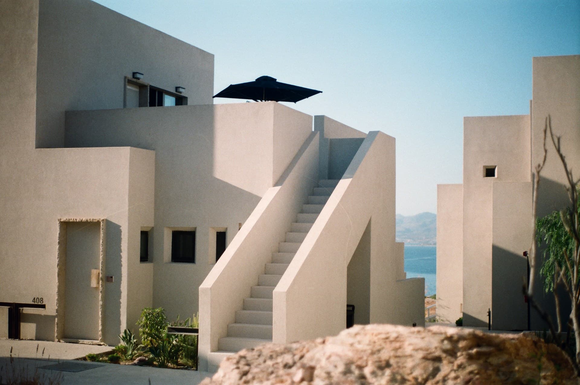 Minimalist stucco villas with a staircase overlooking the sea